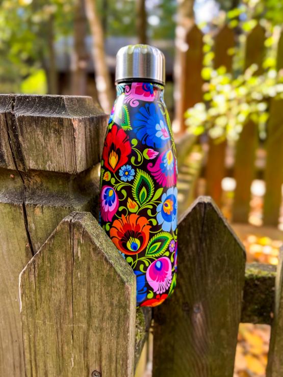 termo bottle decorated with black lowicz pattern next to basket filled with mushrooms