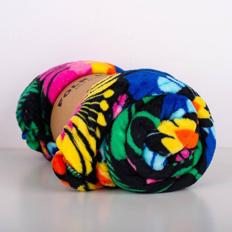 rolled up blanket with lowicz flowers on a black background